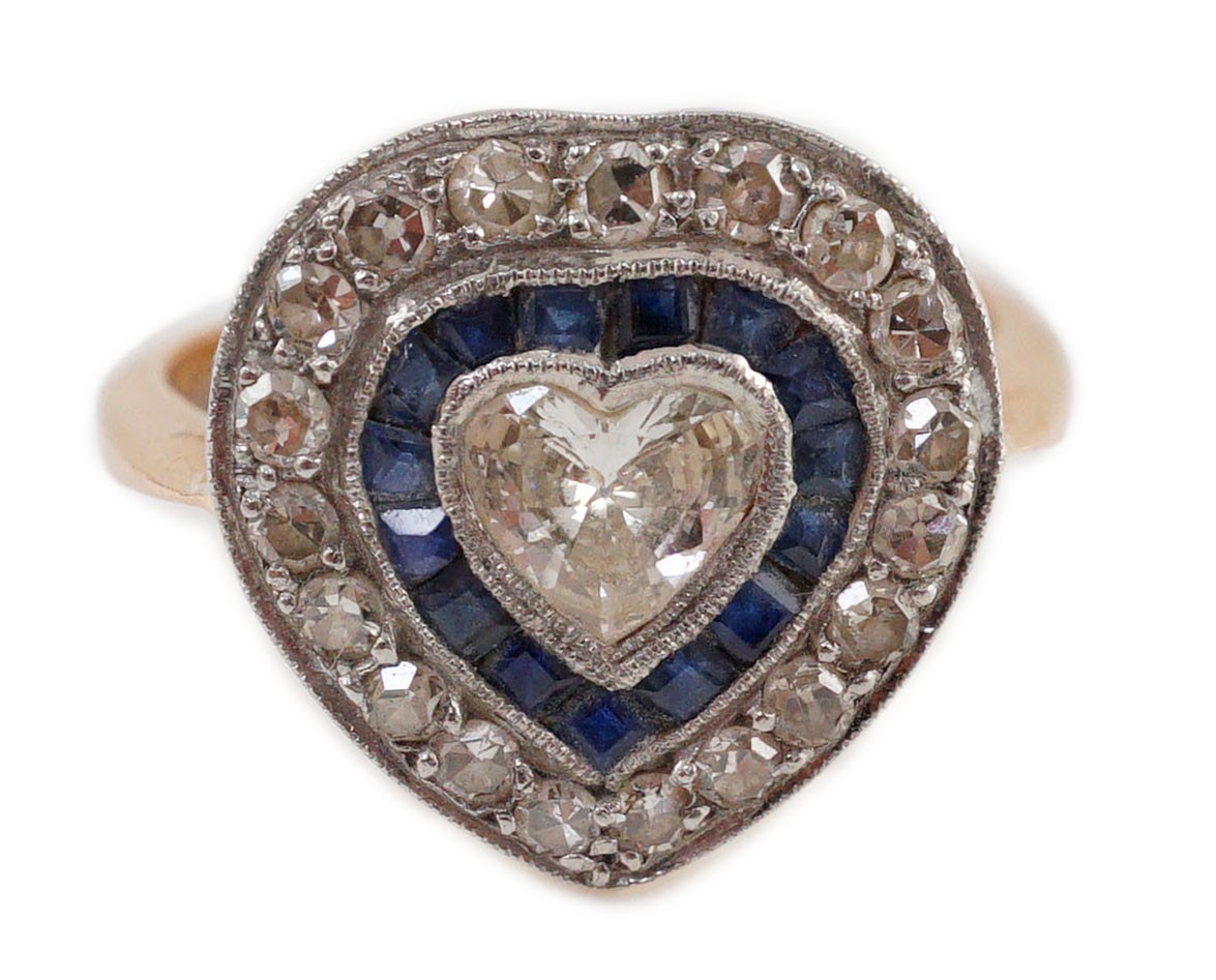 A 1920's, gold and platinum, millegrain set sapphire and diamond cluster set ring, with central heart shaped diamond